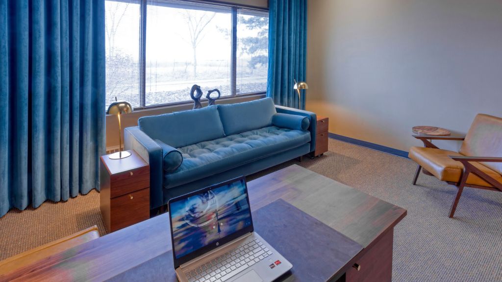 The MK Psychology counselling office in Sherwood Park — a warm, sunlit room with a teal sofa and natural light